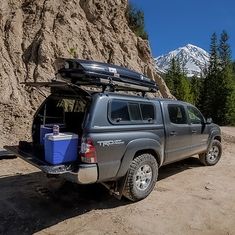 the truck is parked on the side of the mountain