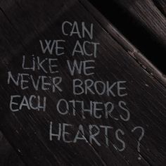 graffiti written on the side of a wooden fence that says can we act like we never broke each others hearts?