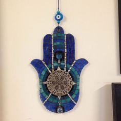 a blue hamsa hanging on the wall