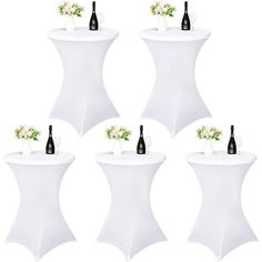 six white tables with wine bottles and flowers on them