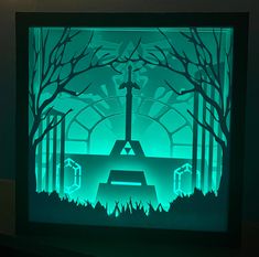 an illuminated paper cut scene with a cross in the middle and trees on either side