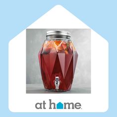 a red glass jar filled with liquid sitting on top of a blue and white background