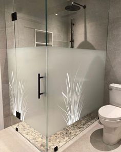 a bathroom with a glass shower stall and toilet