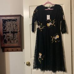 This Dress Is Stunning. Laced 1/2 Sleeves. Complimented With Beautiful Flowers Throughout. V Neck. Lined Black Midi Dress With Lace Trim For Brunch, Black Floral Embroidery Midi Dress, Black Lace Trim Dresses For Spring, Black Midi Dress With Floral Embroidery For Spring, Spring Black Midi Dress With Floral Embroidery, Black Floral Embroidery Midi Dress For Spring, Black Midi Lace Dress For Spring, Black Knee-length Lace Dress For Spring, Black Floral Embroidered Dress For Brunch