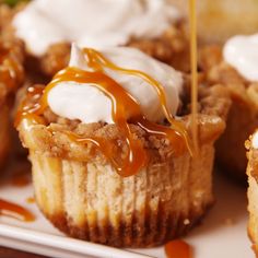 there are many cupcakes with icing on the top and one is being drizzled with caramel