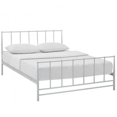 a white metal bed frame with two pillows