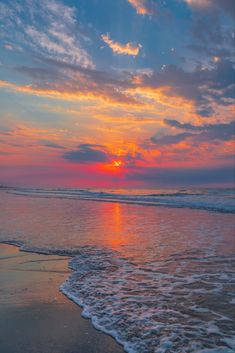 the sun is setting over the water at the beach