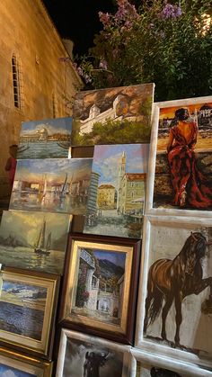 many paintings are on display in front of a building