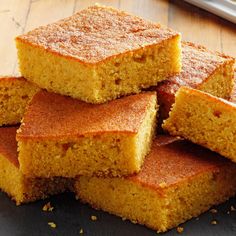 several pieces of cornbread sitting on top of a wooden table next to a knife