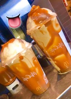 two iced coffees with ice cream and caramel on them sitting on a counter