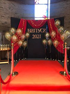 a red carpet with gold and silver balloons on it