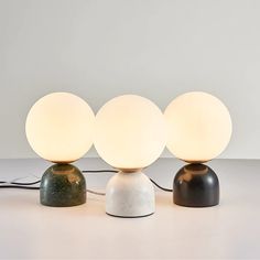 three lamps sitting on top of a table next to each other with one light turned off