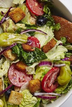 a salad with lettuce, tomatoes, croutons and other toppings