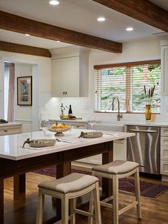 a kitchen with two stools and a center island in front of the stove top