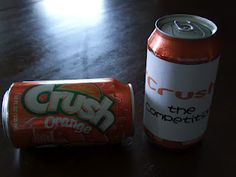 two cans of crush orange soda on a table