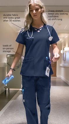 Female medical professional standing in a hospital wearing the UA Butter-Soft STRETCH Women's 4-Pocket Crisscross Scrub Top and 8-Pocket Drawstring Scrub Pants Female Scrubs Doctor, Doctor's Scrub Suit, Medical Scrubs Women, Doctor Scrubs Women Aesthetic, Scrub Suits Design For Nurses, Scrub Ideas Medical, Scrub Designs Medical, Scrubs Styling, Best Scrubs Uniform For Women