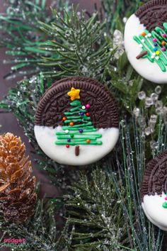 three cookies decorated like christmas trees on top of a tree