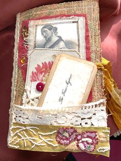 an altered book with lace and buttons on it