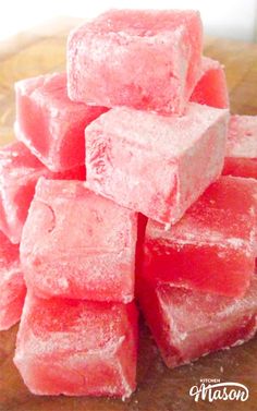 a pile of watermelon cubes sitting on top of a wooden cutting board