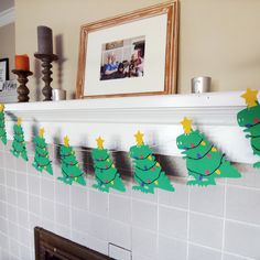 a fireplace mantle decorated with paper christmas trees