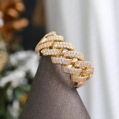 a gold bracelet with white diamonds on top of a mannequin's head