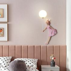 a bedroom with pink walls and polka dot pillows on the bed, along with a wall mounted ballerina figure