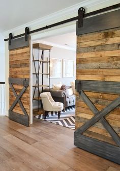 a living room with wooden walls and sliding doors that open up to reveal a couch