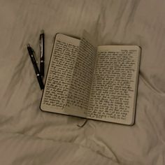 an open book and pen on a bed