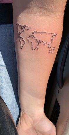 a woman's arm with a small world map tattoo on it