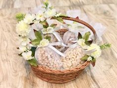 a basket filled with cookies and flowers on top of a wooden floor