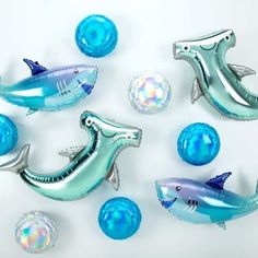 blue and silver foiled dolphin balloons, balls and sea animals on a white background