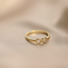 14K Gold Infinity Ring: A simple infinity sign to symbolize eternal and everlasting love, this minimalist ring will make the perfect birthday gift, Valentine's day gift, or Mother's day gift for all of the special people in your life.  Materials & Specifications: - 14K gold ring - Infinity symbol is 4.5mm   As with all of our products, this item is handmade and made to order. **WEARING YOUR JEWELRY** Show your love to your beautifully handcrafted pieces!  Although we stand behind the craftsmanship of our jewelry, our pieces are delicate and not made to be worn during sports and activities such as cleaning and gardening.  When wearing thin/dainty chain bracelets, take care to avoid getting them caught (e.g. on knit sweaters, blankets, or while searching for items in a purse or shopping bag, Simple Infinity Ring Design, Infinity Ring For Couple, Infinity Rings Gold, Infinity Gold Rings For Women, Infinity Gold Ring, Minimal Ring Design, Gold Minimalist Rings, Minimal Rings Gold, Pmj Jewellery