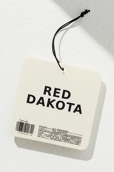 a white tag with the word red dakota printed on it hanging from a black string