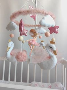 a crib mobile with a ballerina doll hanging from it