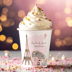 an ice cream sundae with the eiffel tower in the background and confetti scattered around it