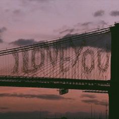 the word love spelled in graffiti on top of a bridge