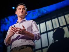 a man standing in front of a screen with his hands together and talking to someone