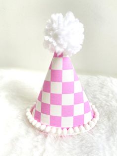 "These MINI party hats are the perfect accessory for your little one's big day or photo session. All hats are made to order. Each hat along with the bows and embellishments are carefully handcrafted so each hat is unique and will vary slightly because of this.  PLEASE LEAVE YOUR EVENT DATE AT CHECKOUT. PARTY HAT FEATURES: -Mini Party Hat (approximately 3\"x5\")  -Pink checker fabric-covered hat designed with a custom template -Optional: add a white glitter number  -White mini pom pom trim and wh Fun Costume Hats For Birthday, Whimsical Adjustable Costume Hats For Birthday, Fun Birthday Party Hat Supplies, Fun Adjustable Birthday Party Supplies, Playful White Party Supplies, Pink Novelty Mini Hats For Gifts, Adjustable Mini Hats With Round Crown For Birthday, Playful White Party Hat, Adjustable Mini Hats With Round Crown For Birthdays