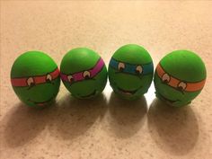 three green eggs with teenage mutant faces painted on them, lined up in a row