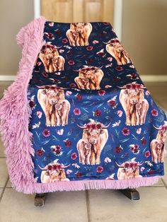 a blue blanket with pink fringes and elephants on it