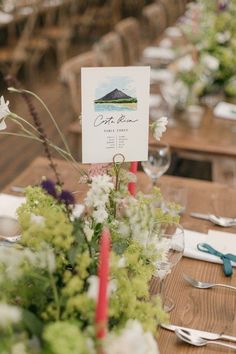 the table is set with place cards, flowers and utensils for guests to eat