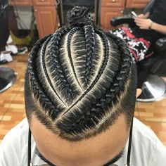 a man with braids on his hair in a barbershop looking at the camera