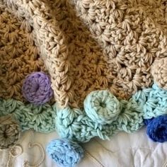 a crocheted blanket laying on top of a bed