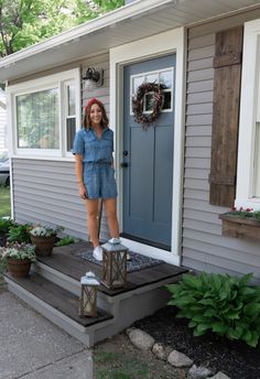 a woman standing on steps in front of a house