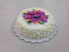 a cake with white frosting and purple flowers on top