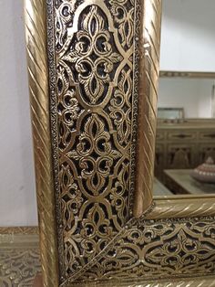 an ornate gold framed mirror sitting on top of a table