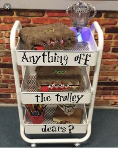 a three tiered shelf with stuffed animals on it and other items in front of a brick wall