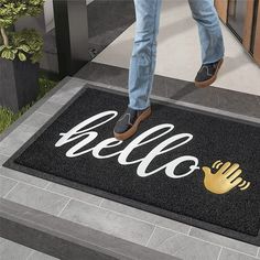 a door mat with the words hello written on it and a hand holding a gold glove