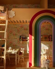 a child's room with a rainbow wallpaper and ladder to the loft bed