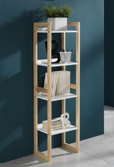 a white shelf with books and plants on it against a blue wall in a room